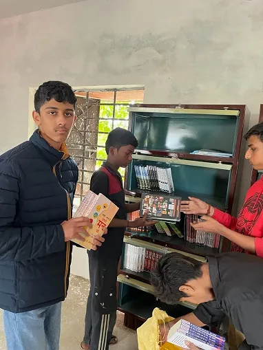 Rohan helping organize the books in the library.