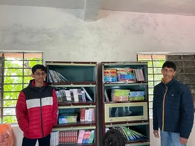 Rohan and Rishabh with some books at the Middle School Fulbari
                  Library